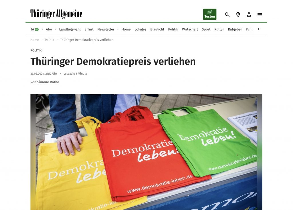Screenshot, TA, 23.05.2024 - Thüringer Demokratiepreis verliehen - Ein Foto zeigt drei bunte, bedruckte Beutel mit der Aufschrift "Demokratie leben"